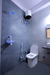 a bathroom with a toilet and a camera on the wall at Hotel Basil Inn in Agra