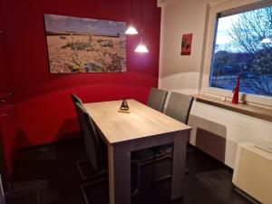 a dining room with a wooden table and chairs at Nordseeperle in Hooksiel +19 photos
