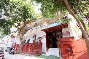 a white building with a red door and a tree at Hotel Basil Inn in Agra