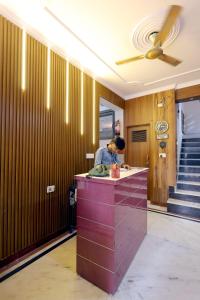 a woman standing at a counter in a hotel lobby at Hotel Basil Inn in Agra