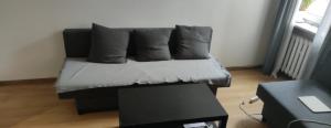 a black couch with pillows sitting in a living room at Rynek aparts in Wrocław