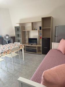 ein Wohnzimmer mit einem Bett und einem Esstisch in der Unterkunft Isola Rossa Appartamenti Standard next to the beach in Isola Rossa