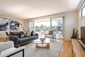 a living room with a couch and a table at Rooftop deck - Central OG - Seaview Luxe in Ocean Grove
