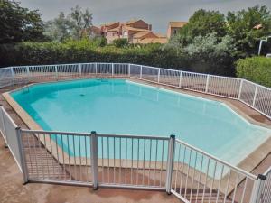 a large swimming pool with a fence around it at Au Fil Des Vagues in Palavas-les-Flots