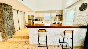 una cocina con 2 taburetes de barra en Chez Nat&Jo, en Le Bois de Nèfles