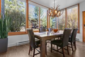 een eetkamer met een tafel en stoelen en grote ramen bij RMR: Yarrow 2311 Condo in The AspensWilson WY in Moose Wilson Road