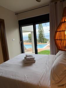 a bedroom with a bed with a view of a pool at Rastoni Suites Xylokastro 1 in Melission