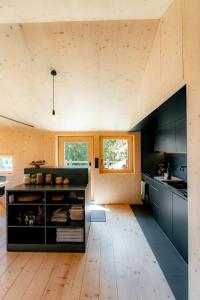 a kitchen with black cabinets and a wooden floor at ALTYPIC Mayen d'exception en Valais in Bruson