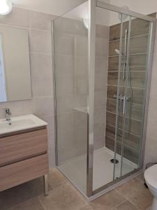 una doccia con una porta in vetro in un bagno di Gîte En Gélion a Sarrant