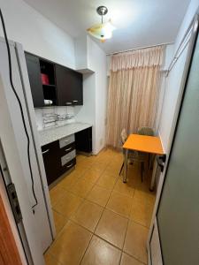 a small kitchen with a table and a desk at Anna`s apartment in Craiova