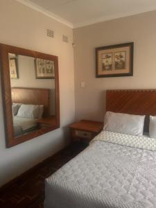 a bedroom with a bed and a large mirror at Nathi Lodge in New Germany