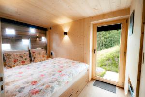 a small bedroom with a bed and a window at Le Mayen ALTYPIC in Bruson