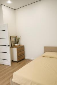 a bedroom with a bed and a dresser and a drawer at Kolsay in Kirovo