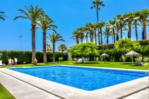 a swimming pool with palm trees in a park at Apartment 511 Torresol, Sea Views in Nerja
