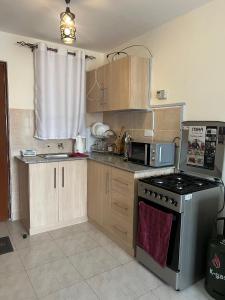 een kleine keuken met een fornuis en een magnetron bij Engra Suites in Nakuru