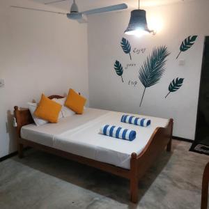 a bedroom with a bed with yellow and blue pillows at moments hotel & restaurant in Hikkaduwa