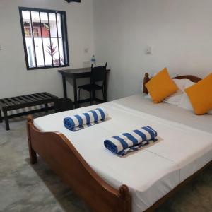 a bedroom with a bed with two pillows on it at moments hotel & restaurant in Hikkaduwa +77 photos