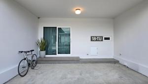 a bike parked in a room with a clock on the wall at 18TU Thammasat in Pathum Thani