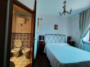 a bedroom with a bed and a toilet at Casina Giulia in Capistrello