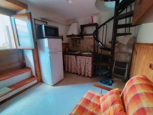 a living room with a refrigerator and a kitchen at Casina Giulia in Capistrello