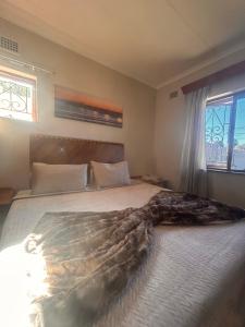 a bedroom with a large bed with a blanket on it at Nathi Lodge in New Germany