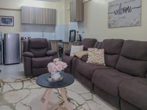 a living room with a couch and a table with flowers at Casa Almasi in Nairobi