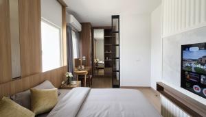 a bedroom with a bed and a flat screen tv at 18TU Thammasat in Pathum Thani