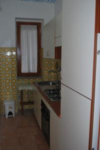 a kitchen with a stove and a sink and a refrigerator at Appartamento Elena in Caramanico Terme
