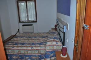 a small bedroom with a bed and a window at Appartamento Elena in Caramanico Terme