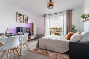 サン・プリエストにあるL'Excellent - Grand Cinema - Grand Marché - Netflixのベッドとテーブルと椅子のある寝室