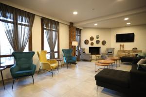a living room with a couch and chairs and a tv at Filoxenia Hotel & Spa in Kalavrita