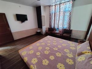 a room with a bed and a tv in it at Hotel Alankar in Manāli +43 photos