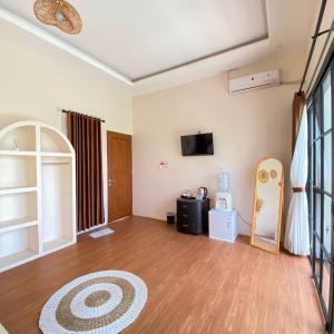 a living room with a wooden floor and a tv at Vikosa Villa Private Pool With View in Yogyakarta +38 photos