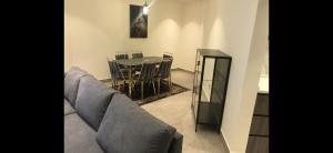 a living room with a couch and a table and chairs at DAMAC Tower Amman boulevard برج داماك - عمان البوليفارد العبدلي in Amman
