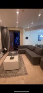 een woonkamer met een bank en een salontafel bij برج داماك - عمان اللويبدة العبدلي البوليفارد in Amman