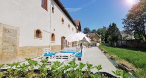 a group of chairs and umbrellas next to a building at Aux Domaines d'Automne in Péronnas
