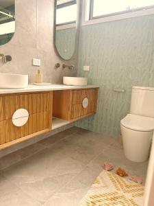 ポートアーリントンにあるCoastal on Clarkeの洗面台、トイレ、鏡のあるバスルーム +9枚の写真