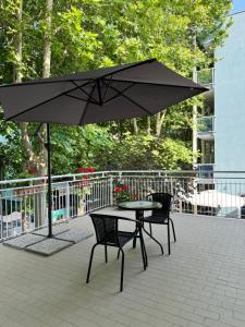 Una mesa y sillas bajo una sombrilla en un patio. en Depandance Blue Hotel, en Cesenatico
