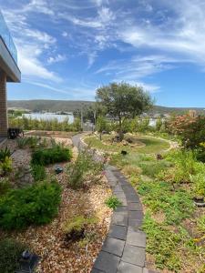 a walkway in a garden with a view of the water at River Daze in Stilbaai