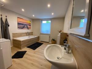 a bathroom with a tub and a sink and a bath tub at Atelier 1a in Cottbus +3 photos
