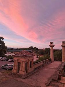 a building with two pillars and a car parked in a parking lot at Stéphanie in Remoulins +18 photos