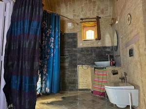 um banheiro com uma pia, um vaso sanitário e uma banheira em Suite Dôme Jasmin em Bin Rhilouf