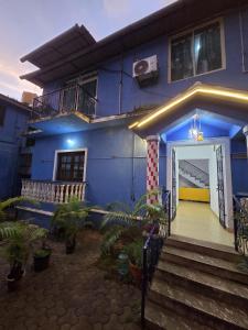 a blue house with a staircase leading to the door at Casa Sumanjo in Calangute
