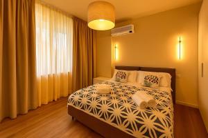 een slaapkamer met een bed en een groot raam bij Green garden apartment in Lignano Sabbiadoro