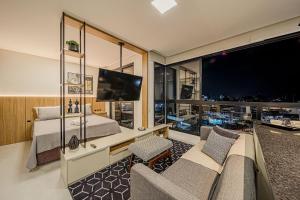 a bedroom with a couch and a bed and a large window at Studio H Residencial Flipchave STH000 in Boa Vista