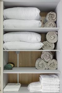 a closet filled with white pillows and blankets at Studio H Residencial Flipchave STH000 in Boa Vista