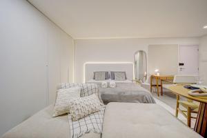 a white bedroom with two beds and a table at Studio H Residencial Flipchave STH000 in Boa Vista +157 photos