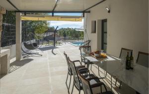 Un patio con mesa y sillas y una piscina. en Stunning Home In Zminj, en Jurići
