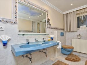 a bathroom with a blue sink and a toilet at Apart Helga in Oberlängenfeld