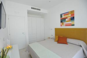 Dormitorio pequeño con cama con almohada naranja en Santa Tecla Flats, en Maiori